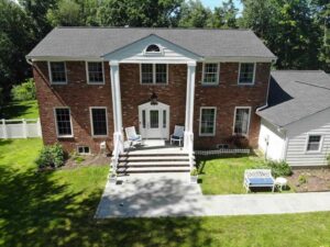 Aerial view of brick home in Armonk, New York with James Hardie siding on side of home