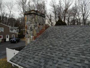 Rooftop with asphalt shingles and chimney with copper flashing
