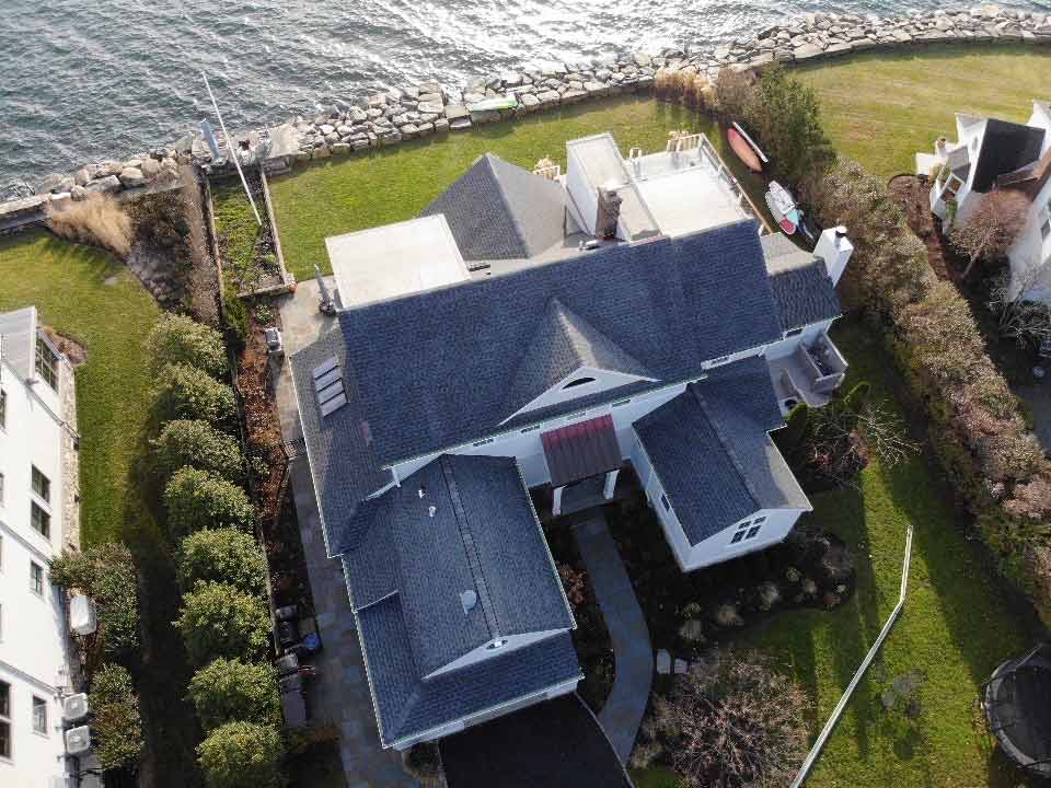 Aerial view of asphalt roof on home by the waterfront