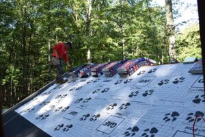 Man on roof installing GAF shingles